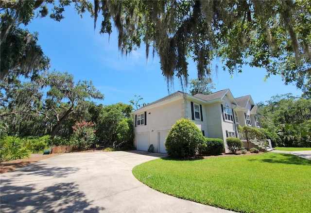 412 Palm Dr, Saint Simons Island, GA 31522 - view of side of property with an attached garage, driveway, a yard, and stucco siding