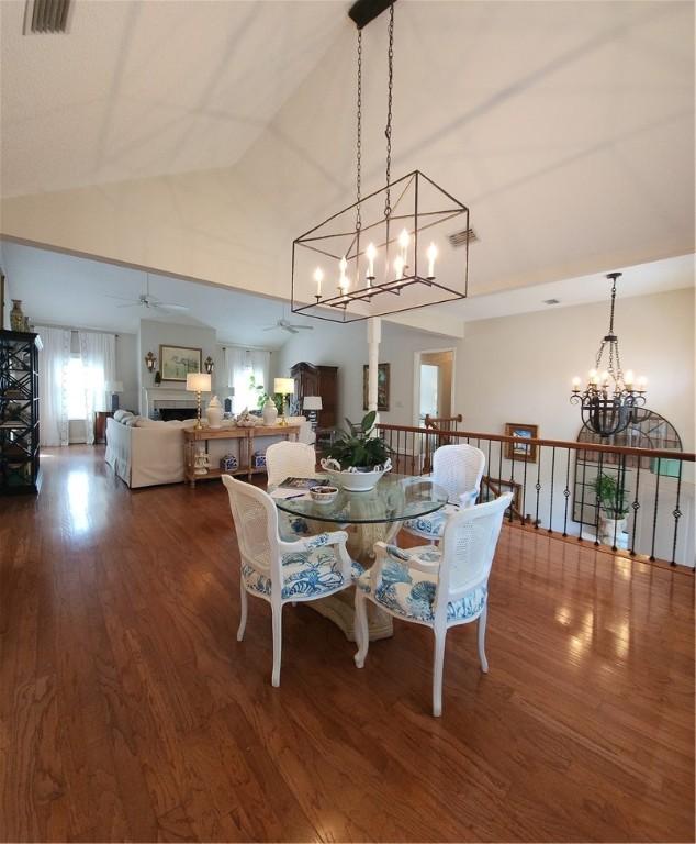 412 Palm Dr, Saint Simons Island, GA 31522 - dining room featuring a chandelier, dark wood-style floors, ceiling fan, and high vaulted ceiling