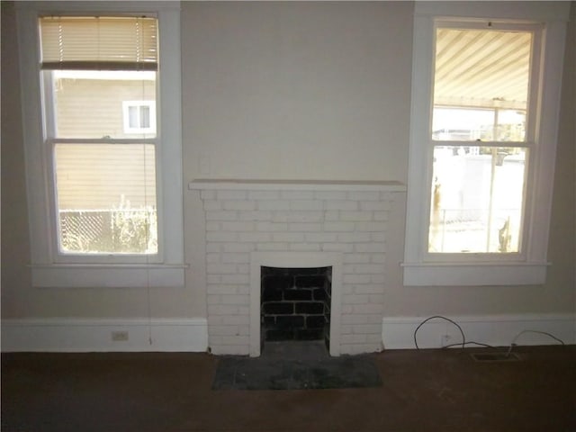 unfurnished living room with a brick fireplace and a wealth of natural light