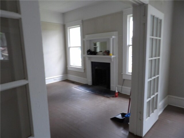 unfurnished living room with a brick fireplace and plenty of natural light