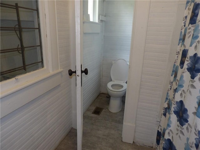 bathroom with toilet and curtained shower