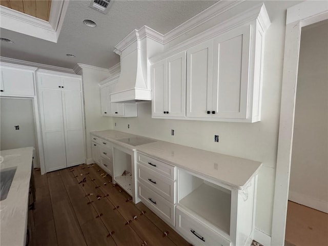 701 Broadwood Dr, Woodbine, GA 31569 - kitchen with premium range hood, black electric cooktop, white cabinetry, dark wood finished floors, and crown molding