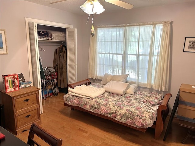 bedroom featuring ceiling fan, a closet, and light hardwood / wood-style flooring