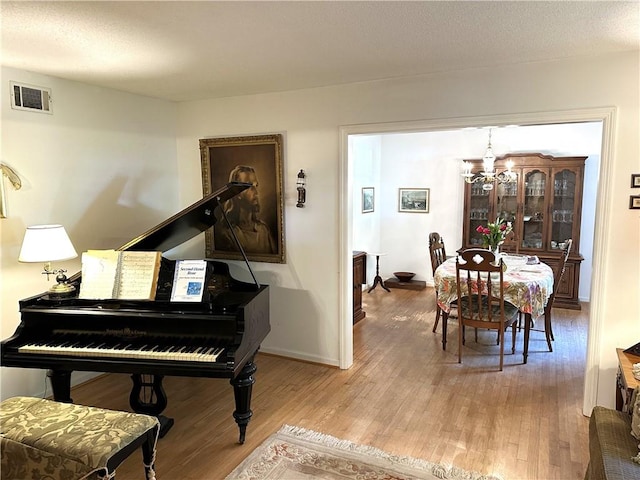 misc room with hardwood / wood-style flooring and a notable chandelier