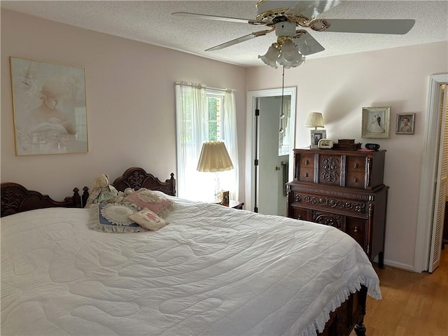 bedroom with a textured ceiling, a closet, light hardwood / wood-style flooring, and ceiling fan