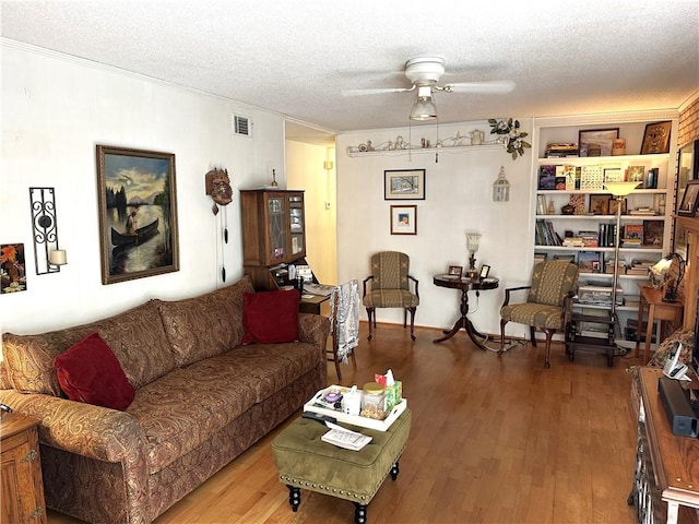 living room with hardwood / wood-style floors, a textured ceiling, and ceiling fan