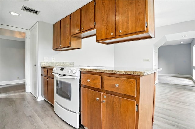422 Fairway Villas Dr, Saint Simons Island, GA 31522 - kitchen featuring white range with electric stovetop, light wood-type flooring, and brown cabinetry