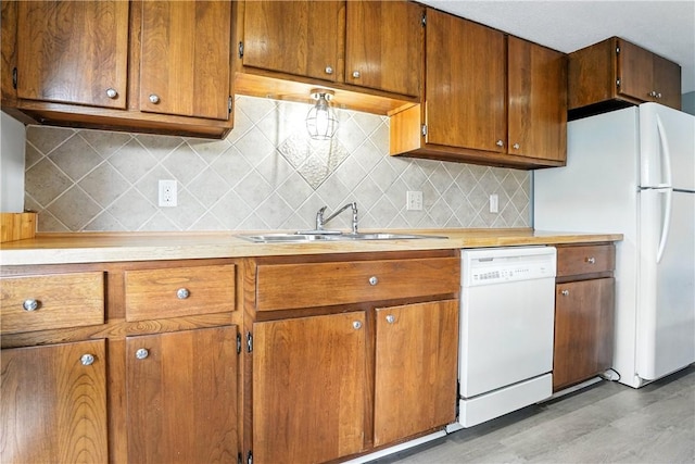 422 Fairway Villas Dr, Saint Simons Island, GA 31522 - kitchen featuring white appliances, light countertops, brown cabinetry, and tasteful backsplash