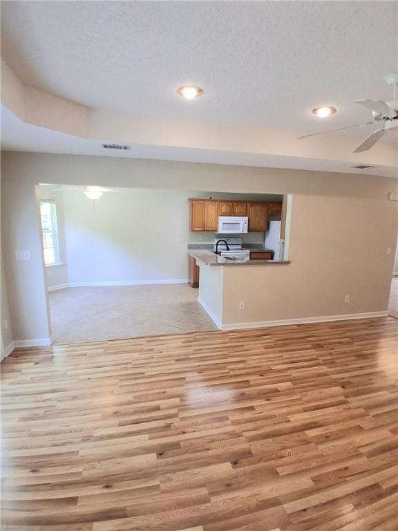 43 Shadowlake Ct, Brunswick, GA 31525 - unfurnished living room featuring light wood-type flooring, ceiling fan, a textured ceiling, and recessed lighting