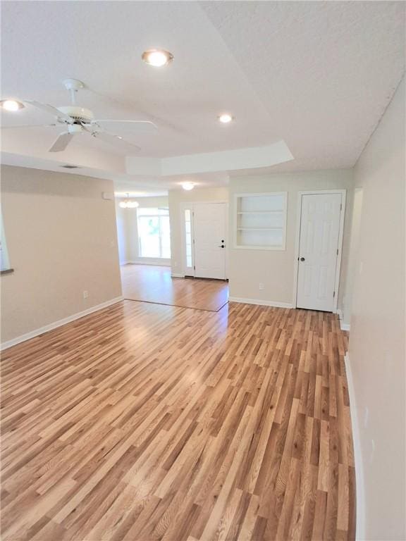 43 Shadowlake Ct, Brunswick, GA 31525 - unfurnished living room featuring light wood-type flooring, recessed lighting, a raised ceiling, and ceiling fan
