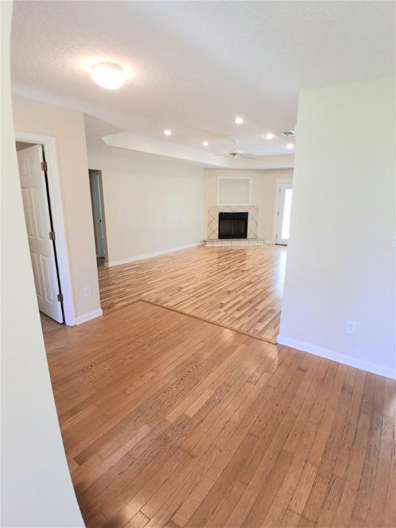 43 Shadowlake Ct, Brunswick, GA 31525 - unfurnished living room with light wood-type flooring, ceiling fan, a tile fireplace, and recessed lighting