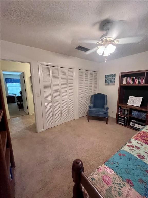 119 Saint Clair Dr, Saint Simons Island, GA 31522 - carpeted bedroom featuring a textured ceiling, two closets, and ceiling fan