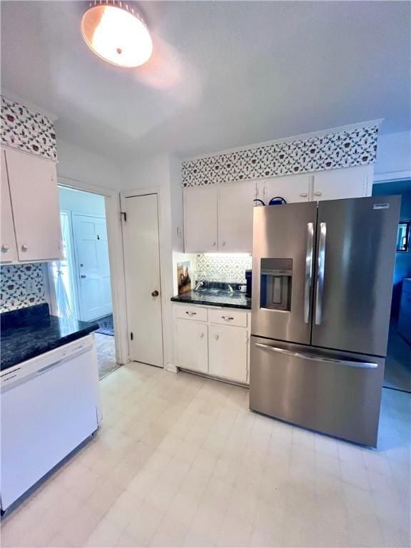 119 Saint Clair Dr, Saint Simons Island, GA 31522 - kitchen featuring stainless steel fridge, dishwasher, dark countertops, tasteful backsplash, and white cabinetry