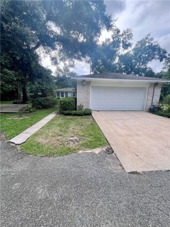 119 Saint Clair Dr, Saint Simons Island, GA 31522 - view of front of property with brick siding, concrete driveway, and a garage