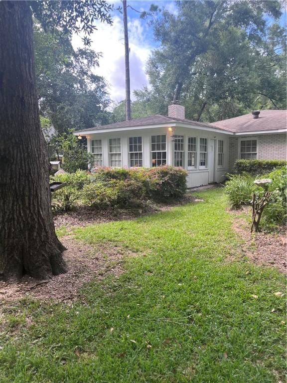 119 Saint Clair Dr, Saint Simons Island, GA 31522 - view of front of home featuring a chimney and a front yard