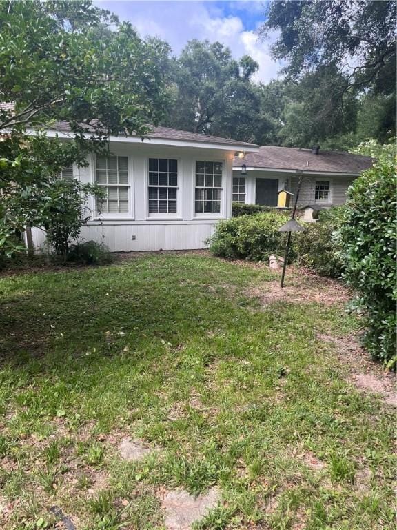 119 Saint Clair Dr, Saint Simons Island, GA 31522 - rear view of property featuring a yard