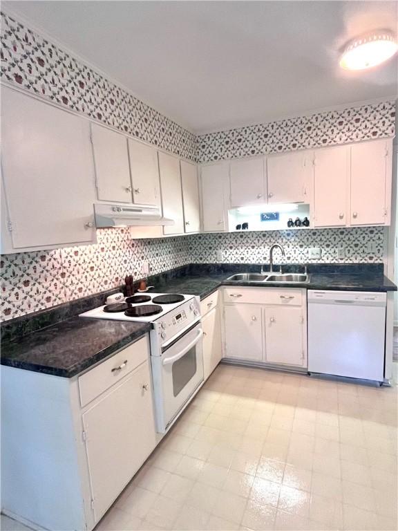 119 Saint Clair Dr, Saint Simons Island, GA 31522 - kitchen featuring white appliances, under cabinet range hood, dark countertops, and light flooring