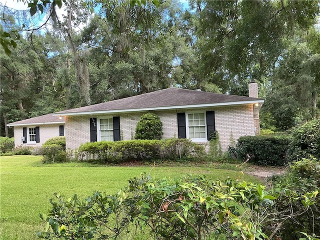 119 Saint Clair Dr, Saint Simons Island, GA 31522 - ranch-style house featuring a chimney, brick siding, and a front yard