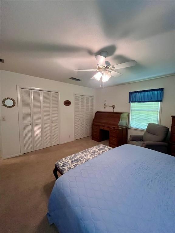 119 Saint Clair Dr, Saint Simons Island, GA 31522 - carpeted bedroom featuring multiple closets and a ceiling fan