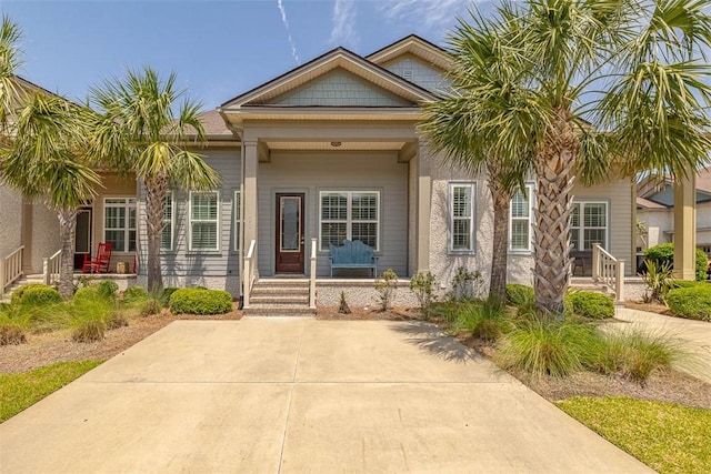 doorway to property with covered porch and stucco siding