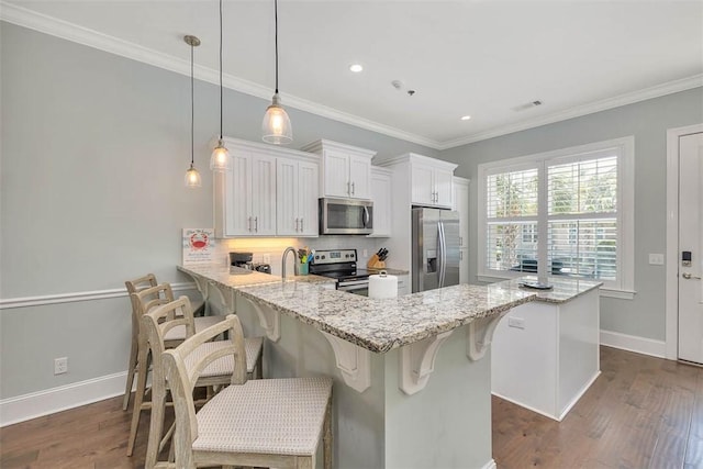 kitchen with dark wood-style flooring, a peninsula, appliances with stainless steel finishes, and tasteful backsplash