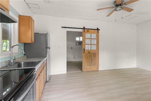 1207 Lanier Blvd, Brunswick, GA 31520 - kitchen with a barn door, light hardwood / wood-style flooring, plenty of natural light, and sink