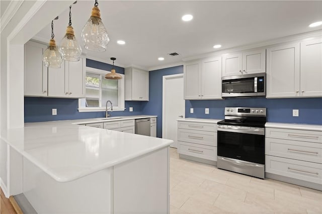 1207 Lanier Blvd, Brunswick, GA 31520 - kitchen featuring kitchen peninsula, white cabinets, stainless steel appliances, and decorative light fixtures