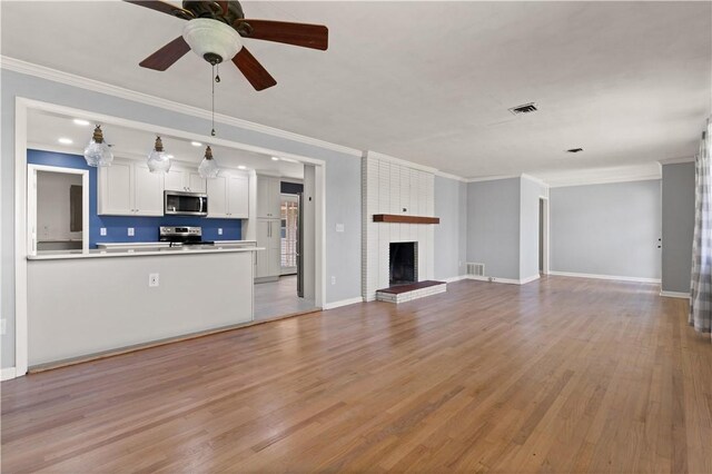 1207 Lanier Blvd, Brunswick, GA 31520 - unfurnished living room with light hardwood / wood-style floors, a brick fireplace, ceiling fan, and crown molding