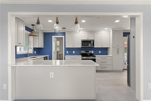 1207 Lanier Blvd, Brunswick, GA 31520 - kitchen with white cabinetry, kitchen peninsula, crown molding, pendant lighting, and appliances with stainless steel finishes