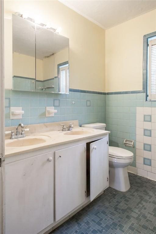 1701 Satilla Blvd, Waycross, GA 31501 - bathroom with tile walls, toilet, double vanity, tile patterned flooring, and wainscoting