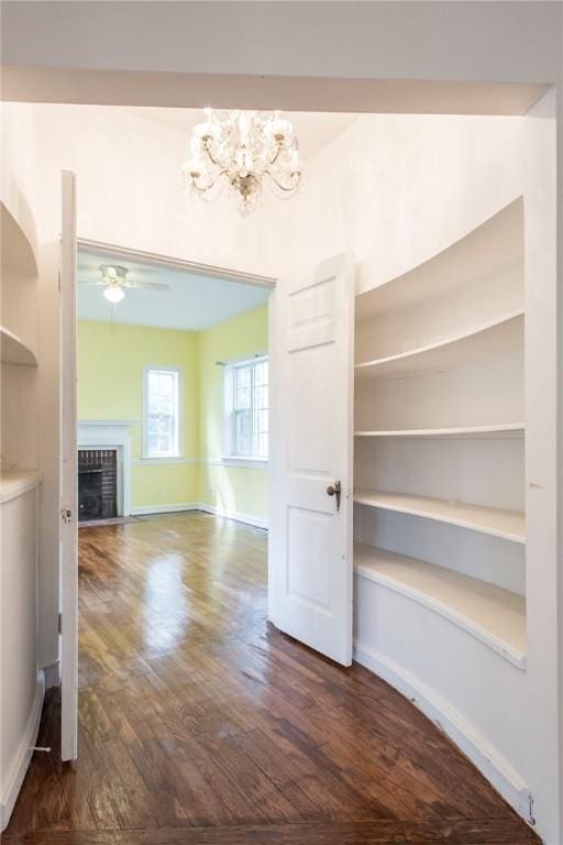 1701 Satilla Blvd, Waycross, GA 31501 - unfurnished dining area with dark wood-style flooring, a fireplace, a ceiling fan, a chandelier, and baseboards