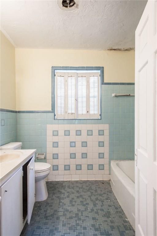 1701 Satilla Blvd, Waycross, GA 31501 - bathroom with tile walls, vanity, toilet, a bath, and wainscoting