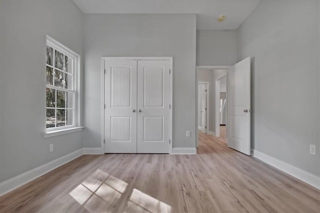 unfurnished bedroom with a closet and light wood-type flooring