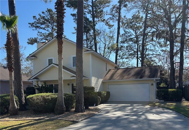 view of home's exterior with an attached garage, a chimney, and driveway