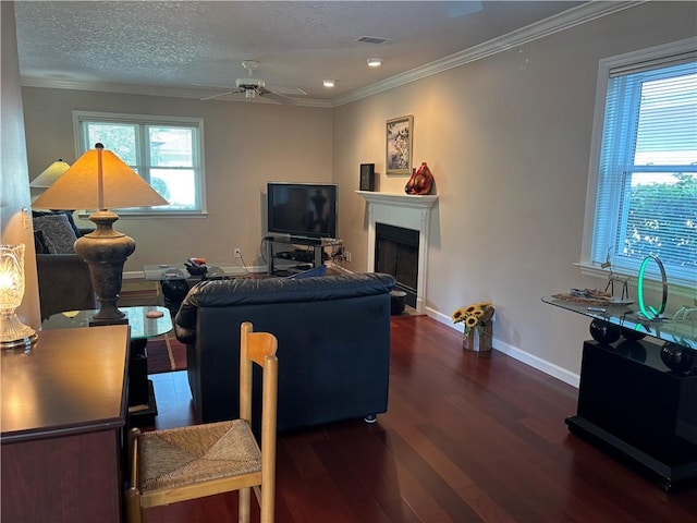 living room with visible vents, crown molding, baseboards, wood finished floors, and a ceiling fan