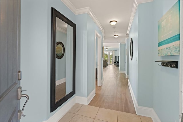 corridor with light hardwood / wood-style flooring and crown molding