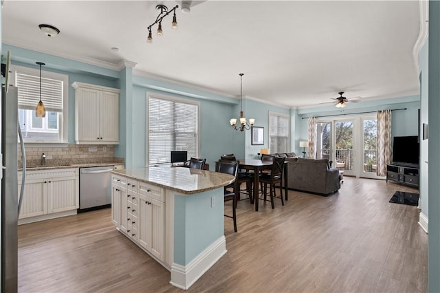 kitchen featuring hanging light fixtures, a kitchen island, stainless steel appliances, and a wealth of natural light