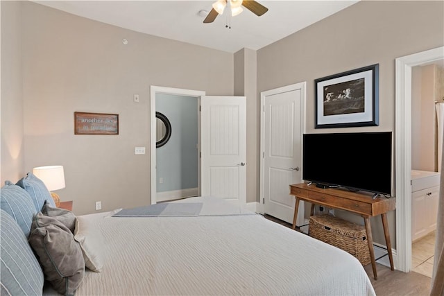 bedroom featuring ceiling fan, light tile patterned flooring, and connected bathroom