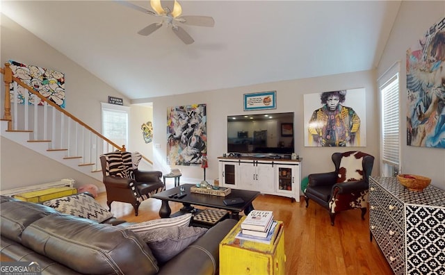 living room with ceiling fan, lofted ceiling, and hardwood / wood-style flooring