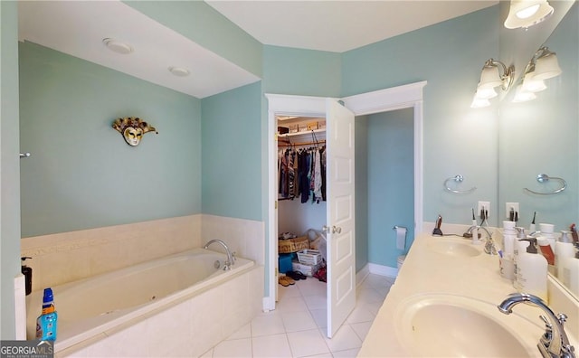 bathroom with tile patterned floors, vanity, and a relaxing tiled tub