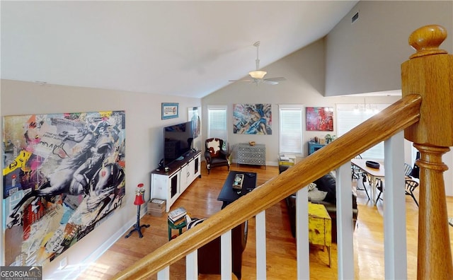 living room featuring ceiling fan, hardwood / wood-style floors, and vaulted ceiling