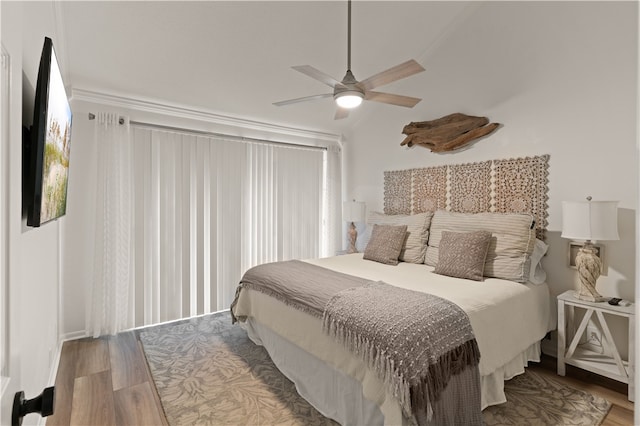 bedroom featuring ceiling fan, hardwood / wood-style floors, lofted ceiling, and ornamental molding