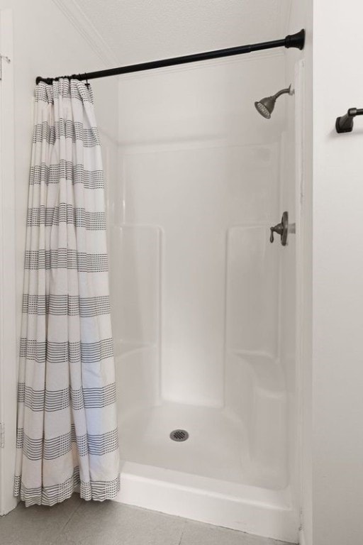 bathroom with a shower with shower curtain, tile patterned flooring, and ornamental molding