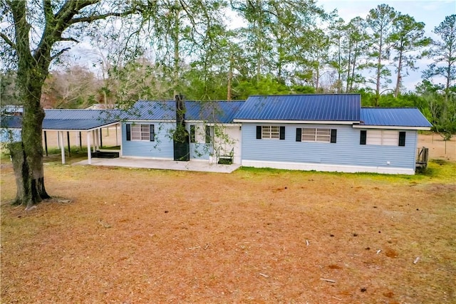 rear view of house featuring a yard and a carport