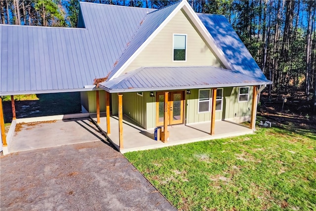 back of house with french doors, a patio area, and a lawn