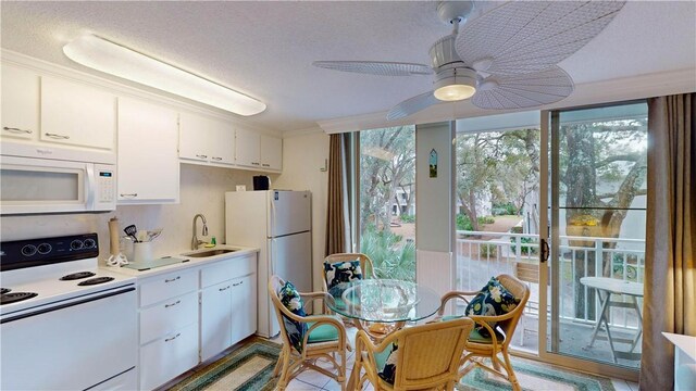 kitchen with ceiling fan, sink, a textured ceiling, white appliances, and white cabinets