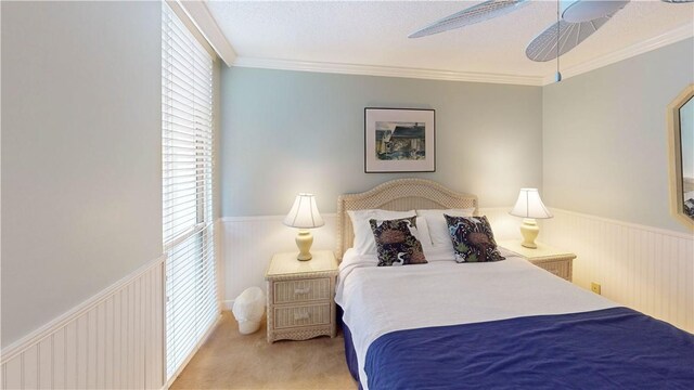 carpeted bedroom with multiple windows, ceiling fan, and crown molding