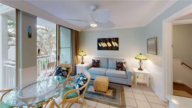 living room featuring ceiling fan, light tile patterned floors, and ornamental molding