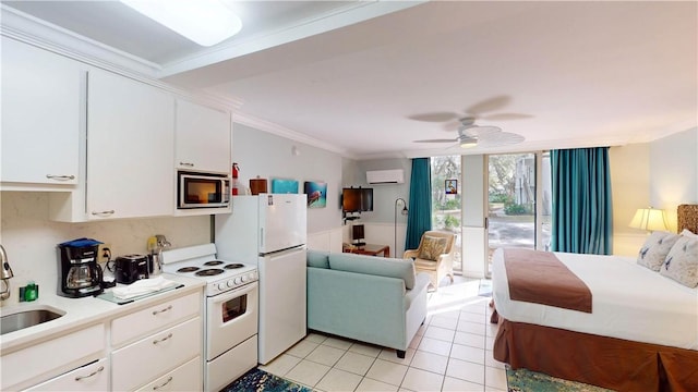 kitchen featuring white appliances, white cabinets, sink, crown molding, and ceiling fan