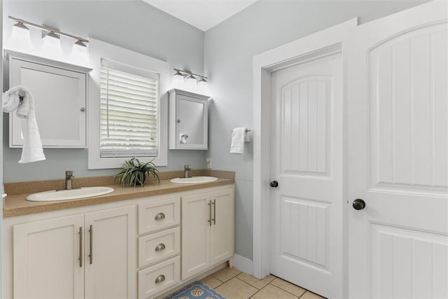 full bathroom with tile patterned flooring, a sink, and double vanity